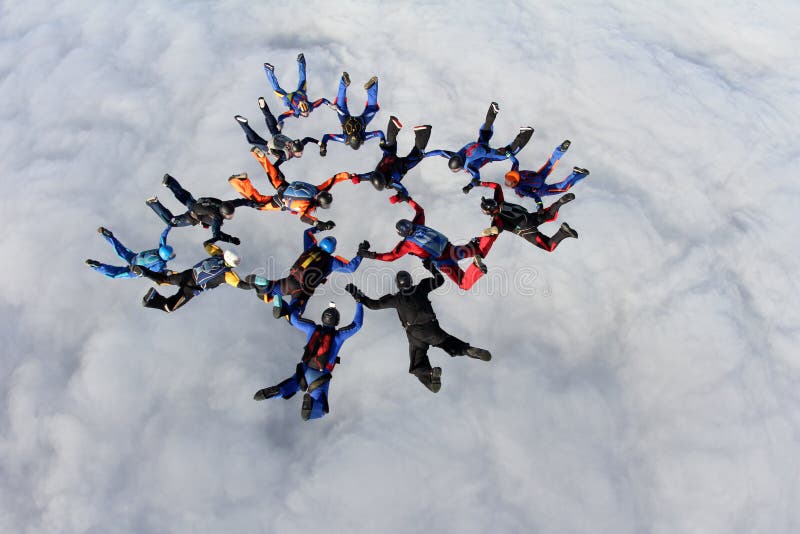 Formacja skydiving Duża grupa skydivers jest w niebie nad białe chmury