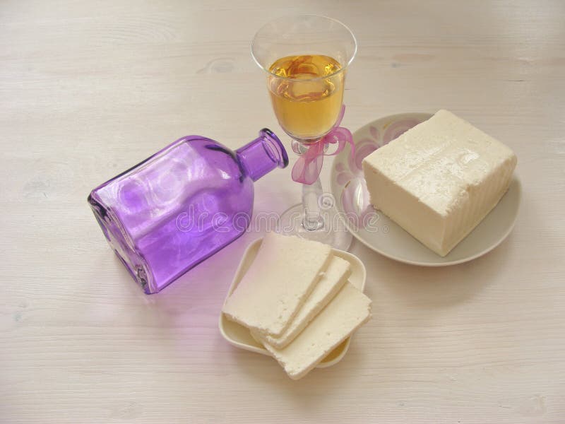 Formaggio del Adygei su fondo di legno bianco con vetro di vino bianco con la bottiglia immagine stock libera da diritti Formaggio del Adygei su fondo di legno bianco con vetro di vino bianco con la bottiglia immagine stock libera da diritti