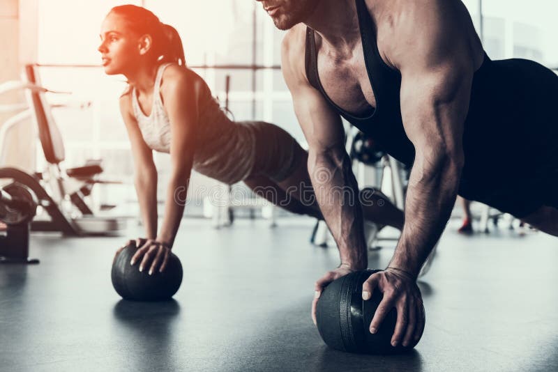 Formation de jeune homme et de femme dans le centre de fitness photographie stock libre de droits Formation de jeune homme et de femme dans le centre de fitness photographie stock libre de droits