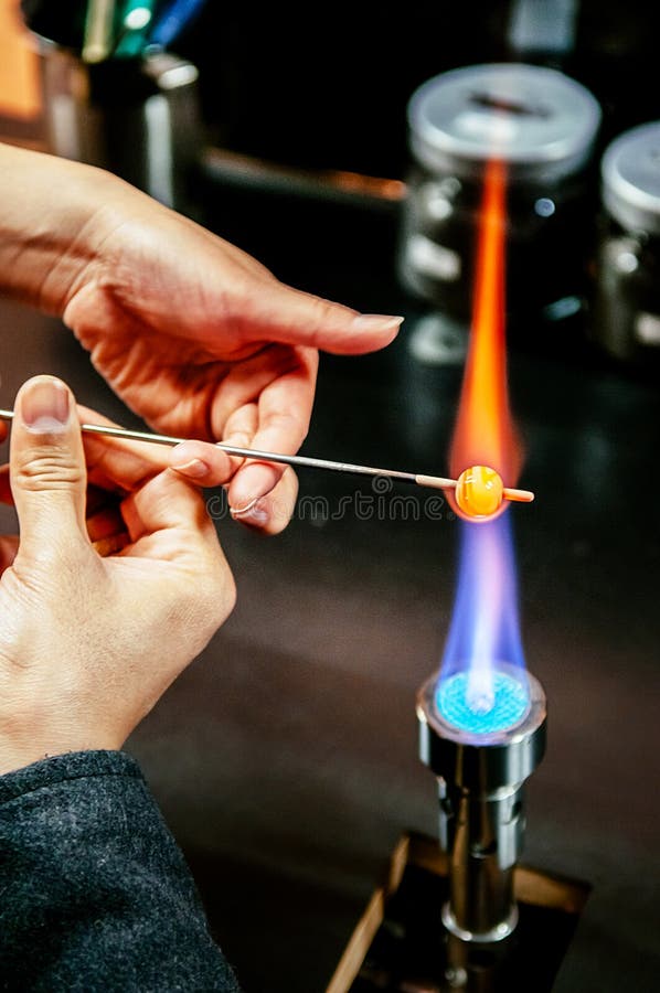 Formation de la perle en verre en feu, artisan de fabrication de verre dans son atelier photo stock Formation de la perle en verre en feu, artisan de fabrication de verre dans son atelier photo stock