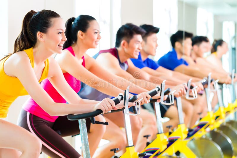 Formation de rotation de vélo de personnes asiatiques au gymnase de forme physique image stock Formation de rotation de vélo de personnes asiatiques au gymnase de forme physique image stock