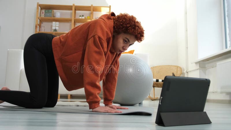 Formation sur la condition physique. Jeune fille africaine en bonne santé faisant de l'exercice sportif sur tapis de yoga à la mai banque de vidéos