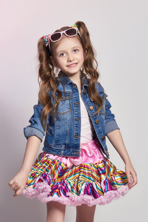 Forme a menina do ruivo em um equipamento festivo que levanta e que sorri Foto do estúdio no fundo colorido luz Aniversário, feri fotografia de stock royalty free Forme a menina do ruivo em um equipamento festivo que levanta e que sorri Foto do estúdio no fundo colorido luz Aniversário, feri fotografia de stock royalty free