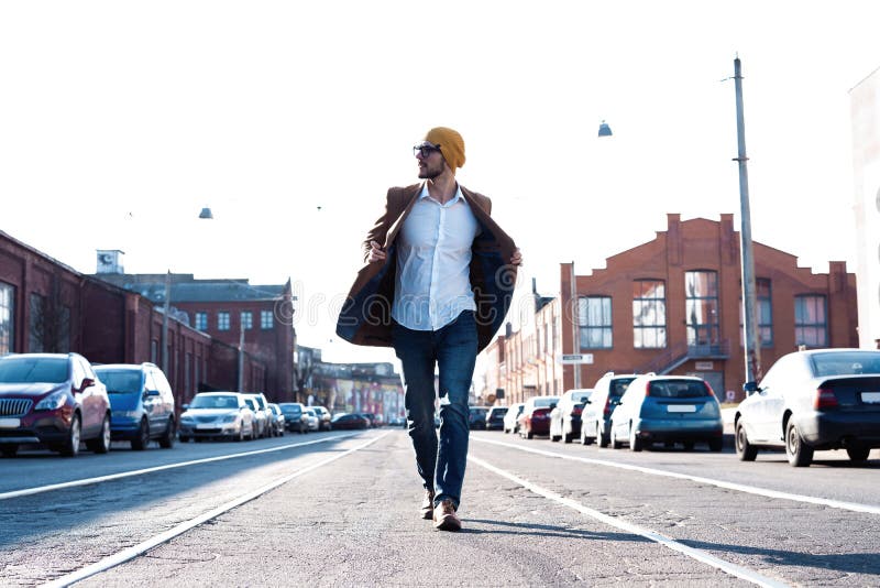 Forme o retrato do homem Homem novo nos vidros que vestem o revestimento que anda abaixo da rua imagens de stock Forme o retrato do homem Homem novo nos vidros que vestem o revestimento que anda abaixo da rua imagens de stock