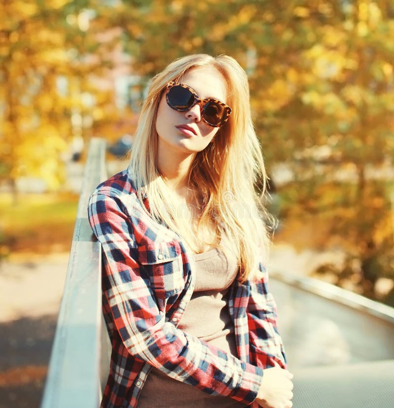 Forme a retrato vestir bonito da mulher óculos de sol e camisa quadriculado na cidade imagens de stock Forme a retrato vestir bonito da mulher óculos de sol e camisa quadriculado na cidade imagens de stock