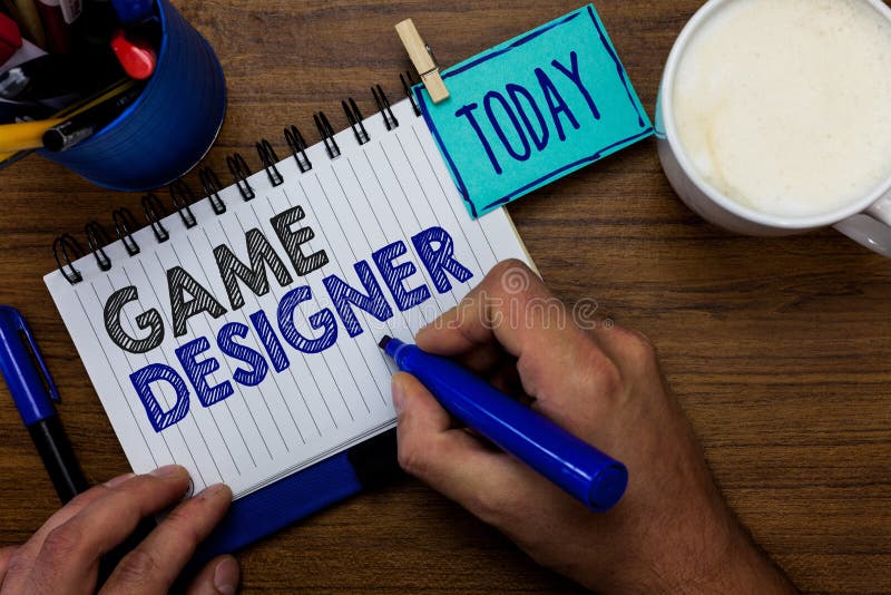 Text sign showing Game Designer. Conceptual photo Campaigner Pixel Scripting Programmers Consoles 3D Graphics Man holding marker notebook clothespin reminder wooden table cup coffee. Text sign showing Game Designer. Conceptual photo Campaigner Pixel Scripting Programmers Consoles 3D Graphics Man holding marker notebook clothespin reminder wooden table cup coffee