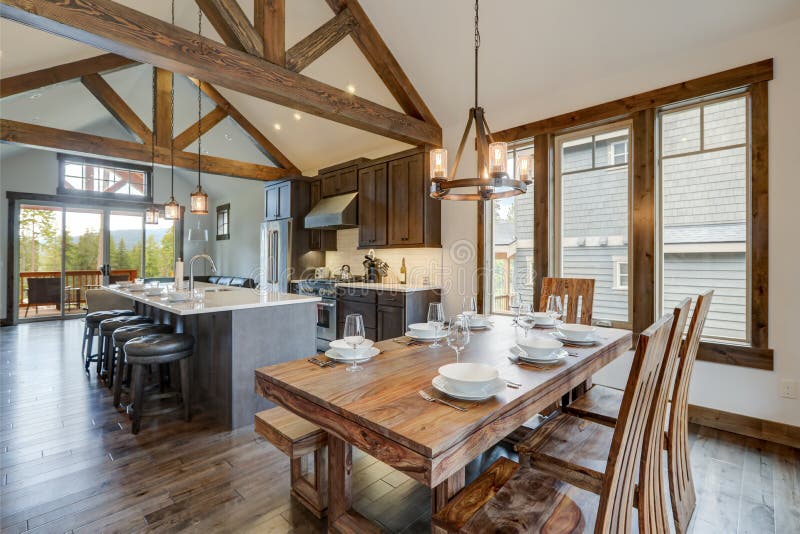 Formidabile sala da pranzo vicino a una cucina moderna e rustica di lusso, con soffitto vagliato e travi di legno lunghe isole con
