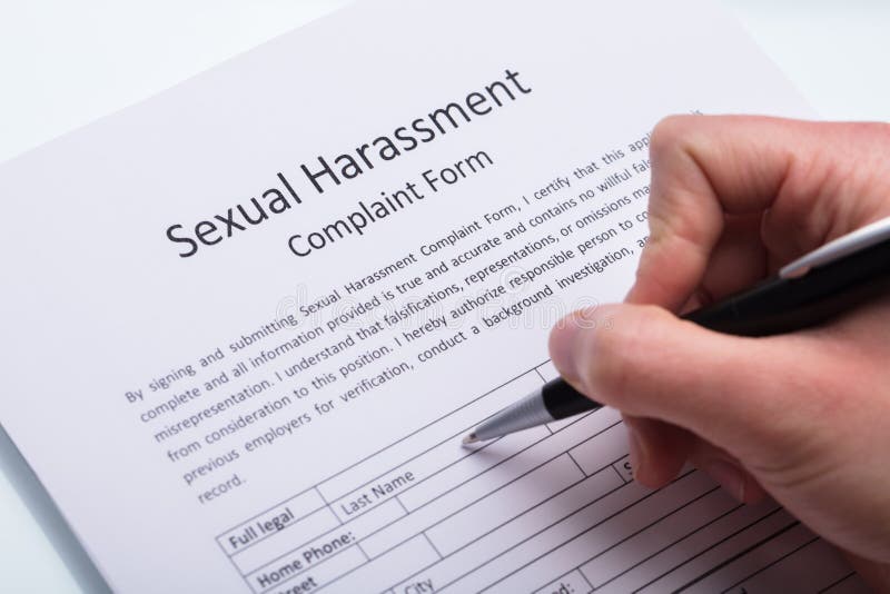 Formulário de enchimento da queixa do acosso sexual da mão humana imagem de stock Formulário de enchimento da queixa do acosso sexual da mão humana imagem de stock