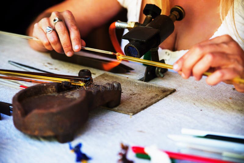 Formung der Glasstange im Feuer stockbilder