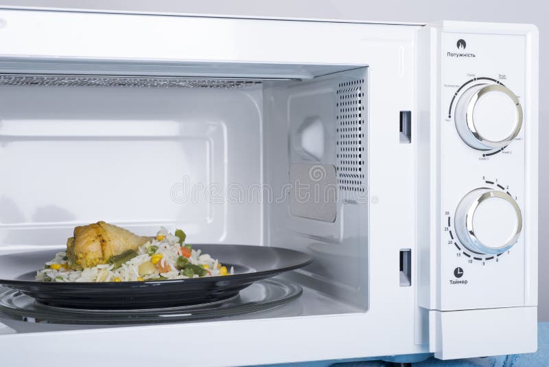 Forno micro-ondas branco, em uma superfície de madeira azul para o alimento de aquecimento foto de stock Forno micro-ondas branco, em uma superfície de madeira azul para o alimento de aquecimento foto de stock