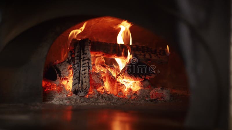 Forno per bruciare pietre con legna da ardere per la cucina di un ristorante italiano. fuoco caldo nella stufa.