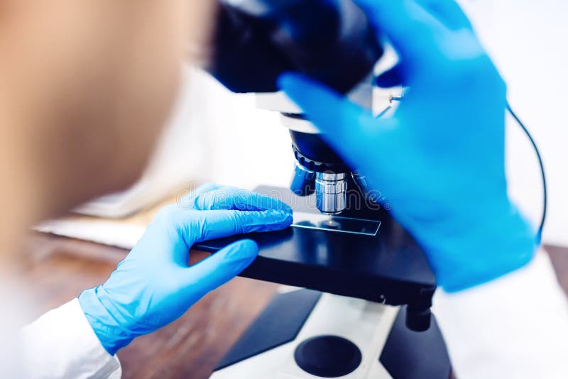Forskaren med mikroskopet som undersöker den lilla kemikalien, sonderar Prövkopior för medicinsk utrustning och laboratorium royaltyfri bild Forskaren med mikroskopet som undersöker den lilla kemikalien, sonderar Prövkopior för medicinsk utrustning och laboratorium royaltyfri bild