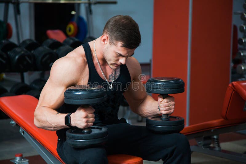 Forte atleta adatto che tiene le teste di legno pesanti fotografie stock Forte atleta adatto che tiene le teste di legno pesanti fotografie stock