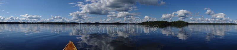 Fortfarande sjöpanorama med kanoten royaltyfri foto Fortfarande sjöpanorama med kanoten royaltyfri foto