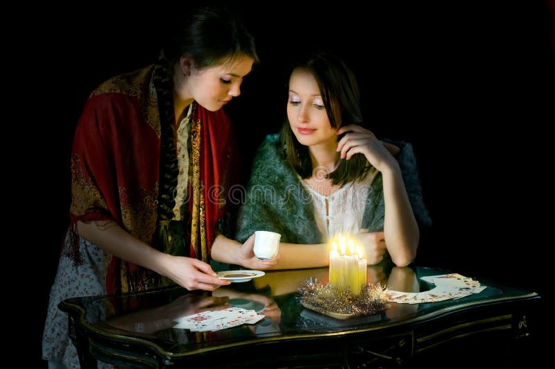 Christmastide fortune-telling: two girls reading coffee grounds. Christmastide fortune-telling: two girls reading coffee grounds