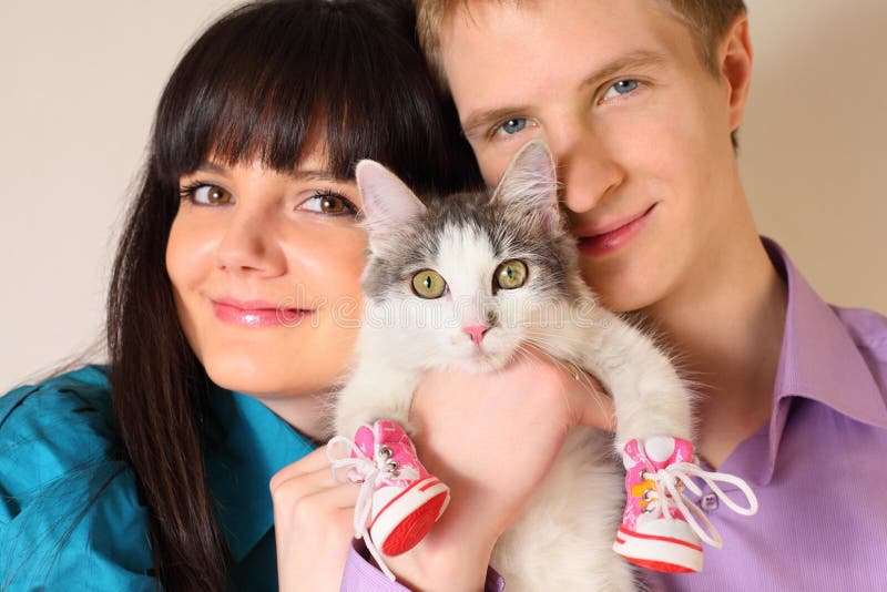 Fortunate young husband and wife hold cat