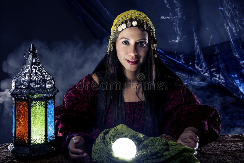 Female fortune teller doing a psychic reading with a cystal ball predicting fate or destiny and the future. The image depicts religion or the paranormal. Female fortune teller doing a psychic reading with a cystal ball predicting fate or destiny and the future. The image depicts religion or the paranormal.