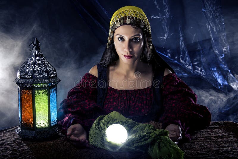 Female fortune teller doing a psychic reading with a cystal ball predicting fate or destiny and the future. The image depicts religion or the paranormal. Female fortune teller doing a psychic reading with a cystal ball predicting fate or destiny and the future. The image depicts religion or the paranormal.