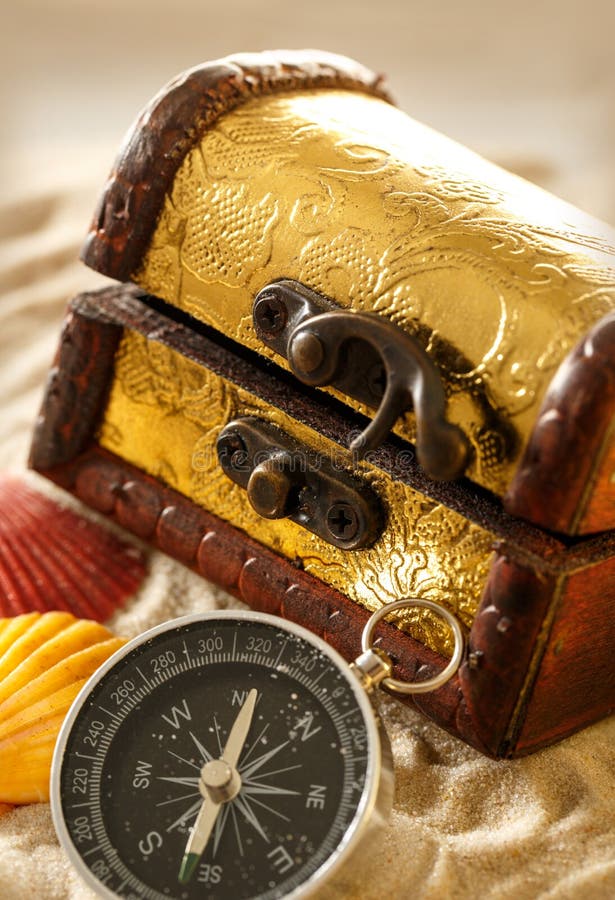 Treasure chest with seashells and compass on sand. Treasure chest with seashells and compass on sand