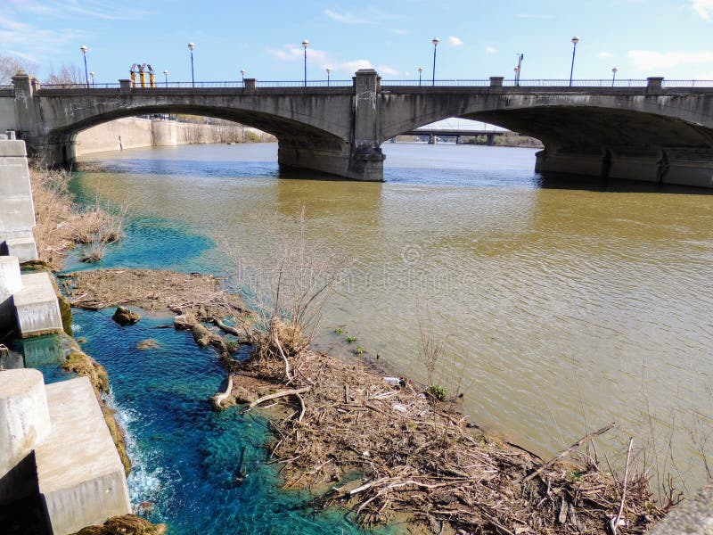 Fot- bro i den White River delstatsparken Indianapolis Indiana med lerig och livlig blandning för blått vatten royaltyfri fotografi Fot- bro i den White River delstatsparken Indianapolis Indiana med lerig och livlig blandning för blått vatten royaltyfri fotografi