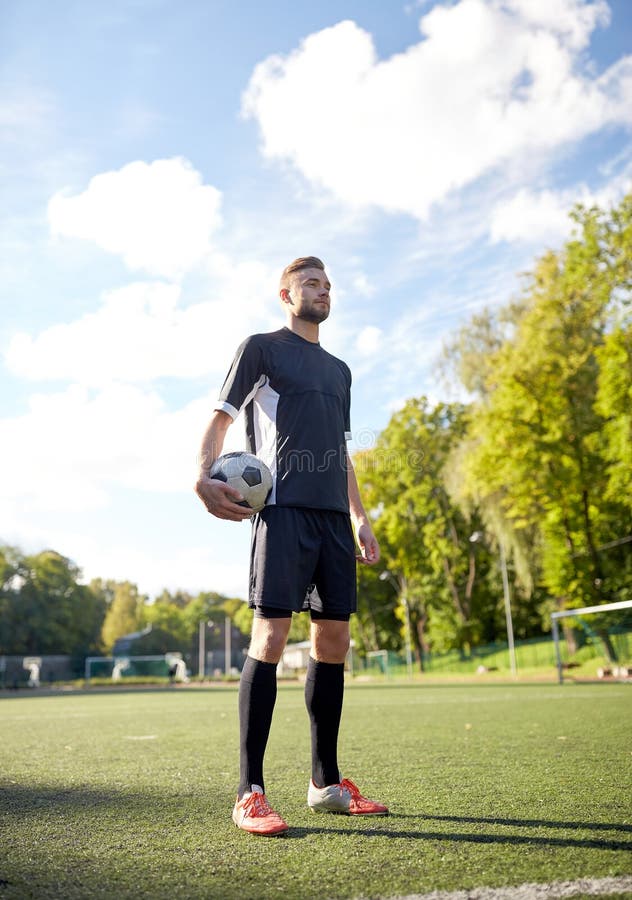 Fotbollspelare med bollen på fotbollfält arkivbild Fotbollspelare med bollen på fotbollfält arkivbild