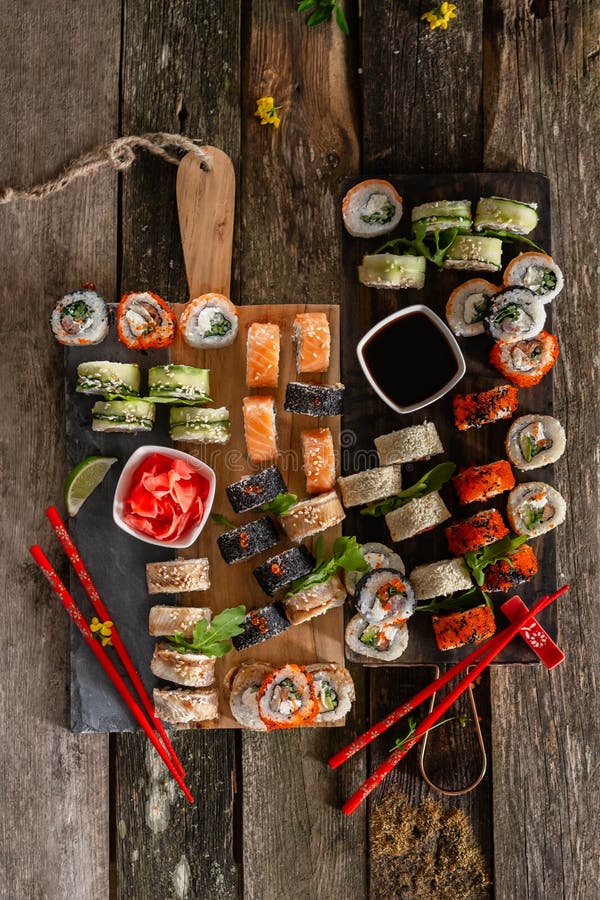 Foto ajustada do alimento do sushi Rolls serviu na placa marrom de madeira e da ardósia Opinião ascendente e superior do fim do s fotos de stock Foto ajustada do alimento do sushi Rolls serviu na placa marrom de madeira e da ardósia Opinião ascendente e superior do fim do s fotos de stock