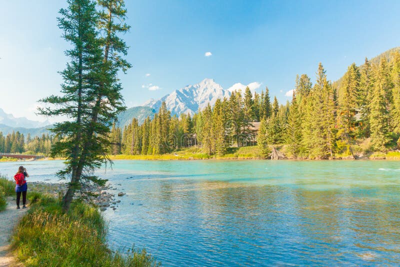 Banff August 2015 In this period of no rain, a woman is taking a picture from this view point to Bow river near Banff to take with her a little peace of this paradise. Banff August 2015 In this period of no rain, a woman is taking a picture from this view point to Bow river near Banff to take with her a little peace of this paradise.