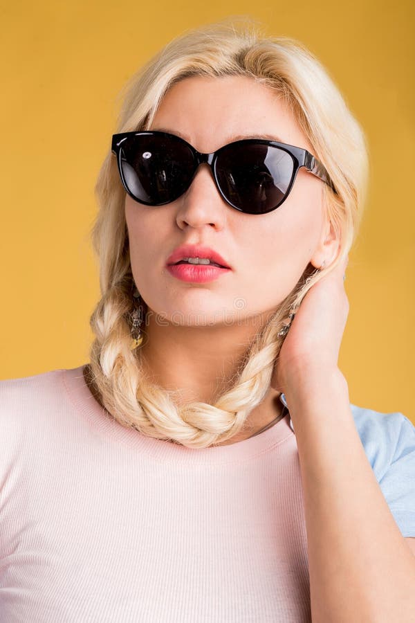 Foto alta vicina di bella donna in occhiali da sole su fondo giallo fotografie stock libere da diritti Foto alta vicina di bella donna in occhiali da sole su fondo giallo fotografie stock libere da diritti