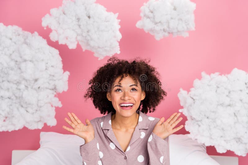 Photo of adorable excited lady wear pajama looking fluffy clouds isolated pink color background. Photo of adorable excited lady wear pajama looking fluffy clouds isolated pink color background.