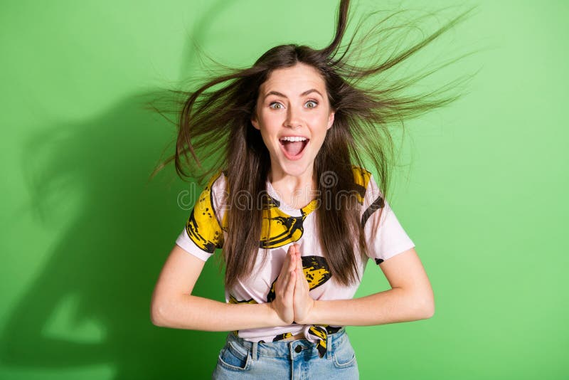 Foto av glad positiv, glad, ung kvinna som klappar händerna flyger hår isolerat på grön skuggbakgrund arkivbild