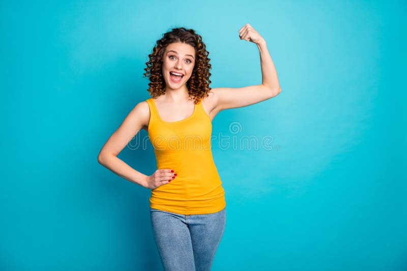 Foto av upphetsande ung dam som öppnar munnen, höj hand på denim jeans yellow singlet blue color royaltyfria bilder