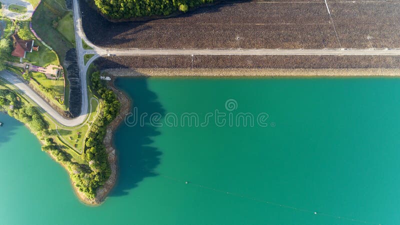 Foto aérea do zangão de voo da estrada asfaltada em torno da represa, paisagem bonita da natureza fotografia de stock royalty free Foto aérea do zangão de voo da estrada asfaltada em torno da represa, paisagem bonita da natureza fotografia de stock royalty free