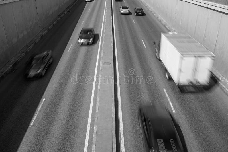 Foto in bianco e nero della strada con le automobili nel moto fotografia stock Foto in bianco e nero della strada con le automobili nel moto fotografia stock