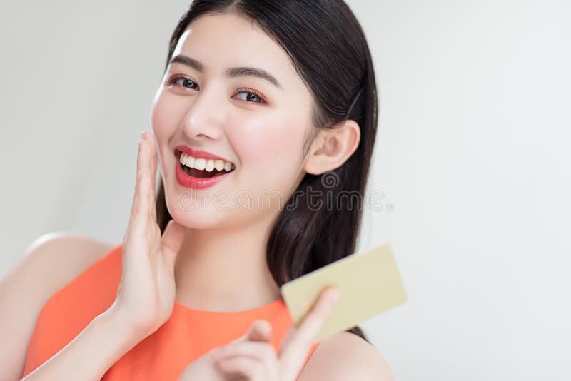 Foto che mostra una ragazza asiatica intelligente con una carta di credito piena di felicità e gioia fotografie stock libere da diritti Foto che mostra una ragazza asiatica intelligente con una carta di credito piena di felicità e gioia fotografie stock libere da diritti