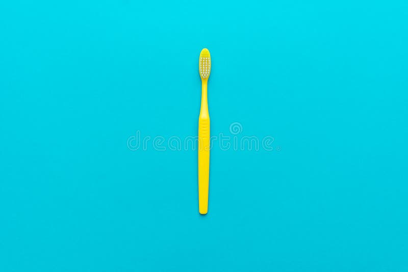 Foto colocada lisa minimalista da escova de dentes amarela sobre o fundo do azul de turquesa fotos de stock Foto colocada lisa minimalista da escova de dentes amarela sobre o fundo do azul de turquesa fotos de stock