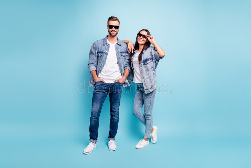 Foto completa di belle donne e uomini con occhiali da sole che sorridono indossando una giacca di jeans in blu
