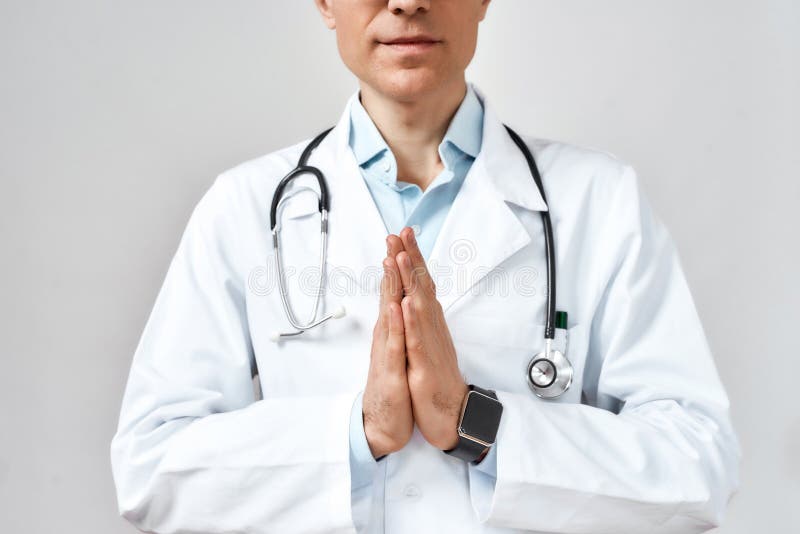 Foto cortada do médico ou médico do sexo masculino em casaco branco com estetoscópio em volta do pescoço rezando a deus por ajuda fotografia de stock royalty free