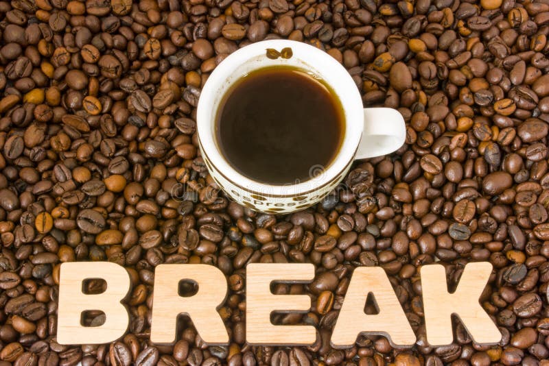 Foto da ruptura de café O copo com café fabricado cerveja está na tabela, que se encheu com os feijões de café roasted, ao lado d foto de stock Foto da ruptura de café O copo com café fabricado cerveja está na tabela, que se encheu com os feijões de café roasted, ao lado d foto de stock