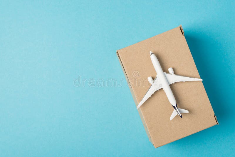 Foto de arriba de avión y caja donación de ayuda humanitaria aislada en el fondo azul con copyspace.