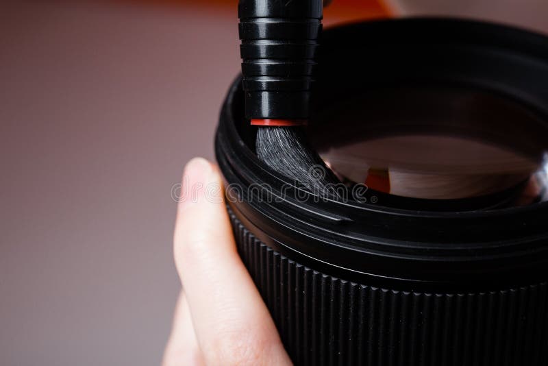 Close-up photo of the process of cleaning the camera lens with a professional brush. Macro photography of objects. Close-up photo of the process of cleaning the camera lens with a professional brush. Macro photography of objects