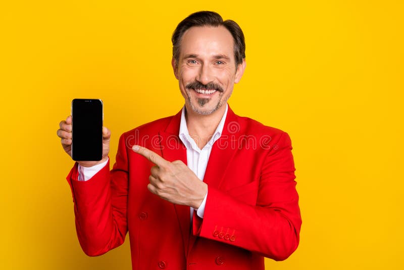 Photo of elegant luxury well-dressed man advertising smartphone touch screen isolated on yellow color background. Photo of elegant luxury well-dressed man advertising smartphone touch screen isolated on yellow color background.