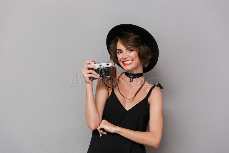 Foto de la mujer caucásica 20s que lleva el photogr negro del vestido y del sombrero foto de archivo Foto de la mujer caucásica 20s que lleva el photogr negro del vestido y del sombrero foto de archivo