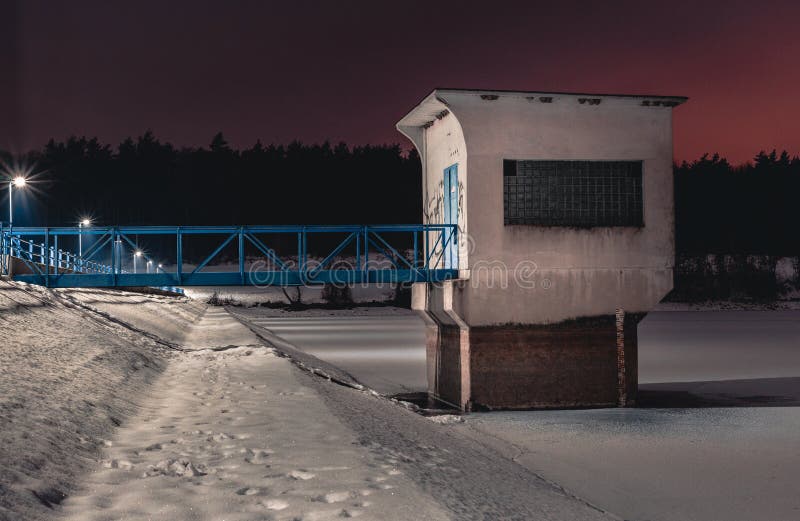 Foto de la noche del edificio cerca del depósito congelado en invierno Lago nevado con el puente fotos de archivo Foto de la noche del edificio cerca del depósito congelado en invierno Lago nevado con el puente fotos de archivo