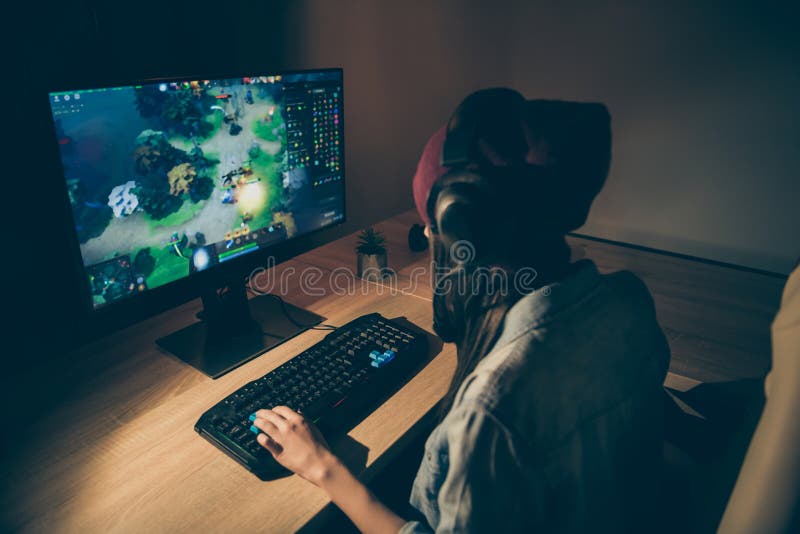 Foto de la parte trasera de una novia jugando un videojuego con sus amigos hablando con ellos delante del teclado imagenes de archivo Foto de la parte trasera de una novia jugando un videojuego con sus amigos hablando con ellos delante del teclado imagenes de archivo