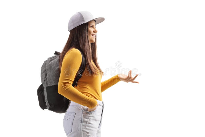Foto de perfil de una estudiante con una mochila y la parte superior amarilla con la mano foto de archivo libre de regalías