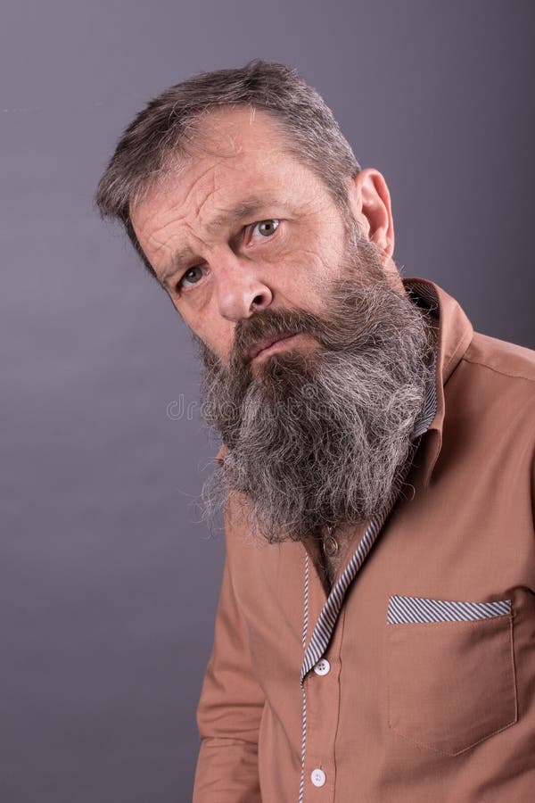 Foto de um ancião mal-humorado irritado que olha desagradado muito Homem masculino com a barba longa em sua cara Feche acima da f foto de stock Foto de um ancião mal-humorado irritado que olha desagradado muito Homem masculino com a barba longa em sua cara Feche acima da f foto de stock