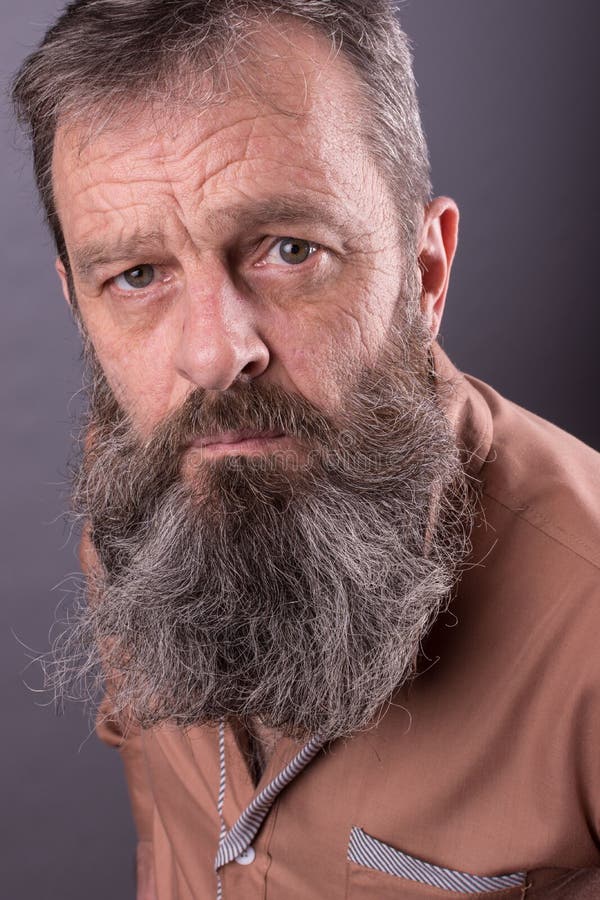 Foto de um ancião mal-humorado irritado que olha desagradado muito Homem masculino com a barba longa em sua cara Feche acima da f fotos de stock royalty free Foto de um ancião mal-humorado irritado que olha desagradado muito Homem masculino com a barba longa em sua cara Feche acima da f fotos de stock royalty free