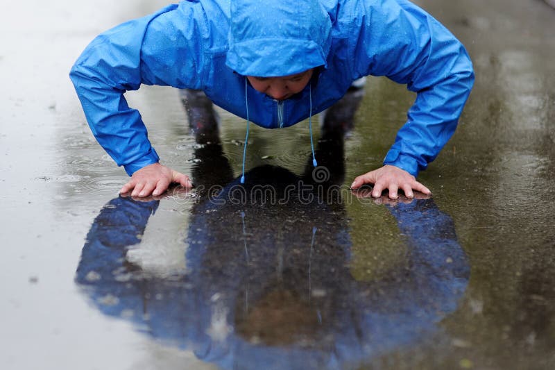 Foto de uma mulher atlética nova que exercita na chuva foto de stock royalty free Foto de uma mulher atlética nova que exercita na chuva foto de stock royalty free