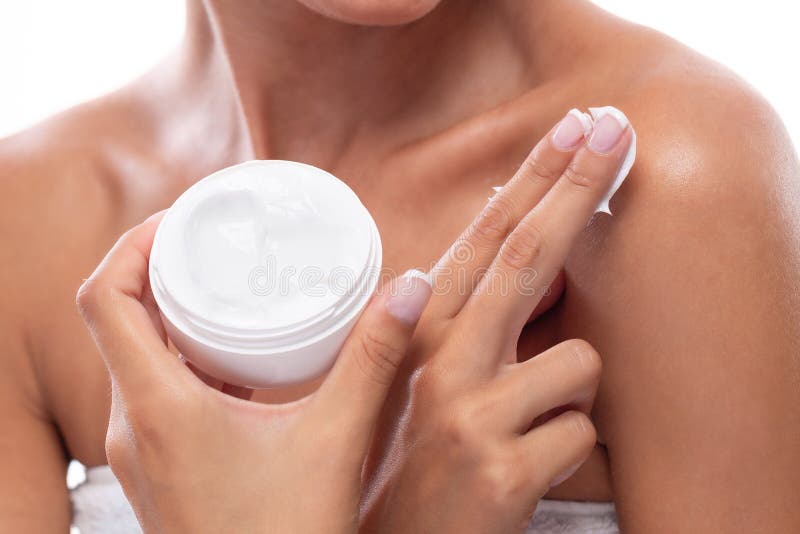 Photo of young girl rubbing body cream on her skin with two fingers. Photo of young girl rubbing body cream on her skin with two fingers