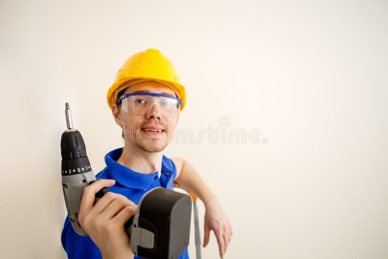 Foto degli uomini con il trapano ed in casco giallo immagine stock Foto degli uomini con il trapano ed in casco giallo immagine stock